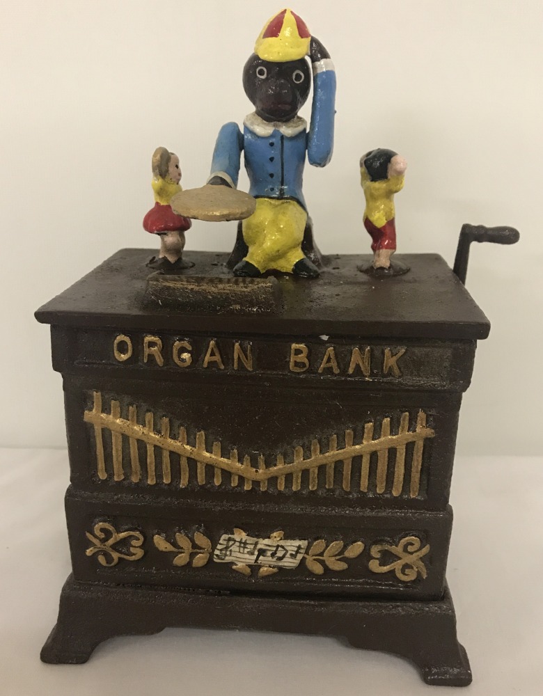 A wind up cast iron money box of an organ with monkey.