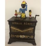 A wind up cast iron money box of an organ with monkey.