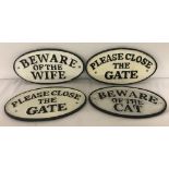 4 oval shaped cast iron wall signs, painted black and white.