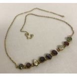 A decorative gem set necklace in need of repair.