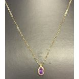 A 9ct gold fine curb chain necklace with an oval cut amethyst drop pendant.