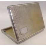 An Art Deco silver cigarette case with engine turned decoration and empty cartouche.