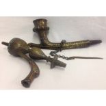 A heavy bronze highly decorated smoking pipe with attached chain and tamper cleaning tool.