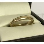 A 9ct gold wedding band. Size M½.