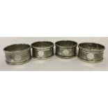 4 matching Art Deco silver serviette rings with engine turned decoration and empty cartouches.
