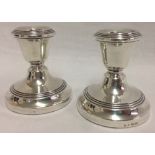 A pair of small silver candlestick holders with simple turned decoration.