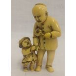 A very finely carved, 19th century Japanese ivory netsuke of a father and child, signed.