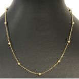 A 9ct gold necklace of alternating ball and fine curb chain decoration.