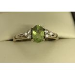 A ladies 9ct gold peridot and clear stone dress ring.