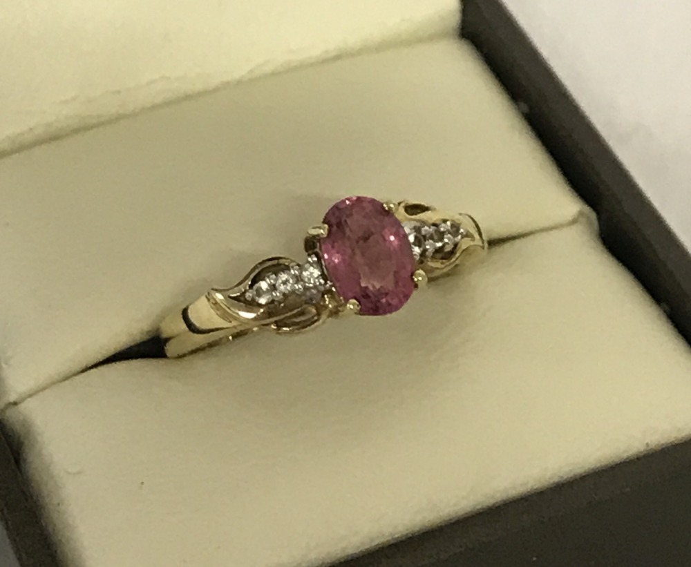 A 9ct gold ladies dress ring set with central oval cut pink tourmaline.