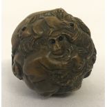 A signed carved wood, spherical shaped netsuke.