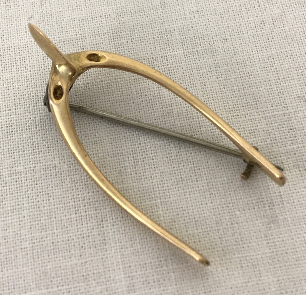 A vintage brooch in the shape of a wishbone. Tests as 9ct gold.