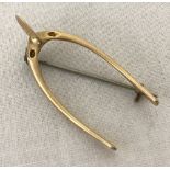 A vintage brooch in the shape of a wishbone. Tests as 9ct gold.