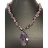 A natural rough cut amethyst stone necklace with lobster clasp.