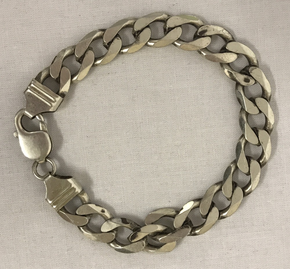 A heavy curb chain silver bracelet with lobster clasp.