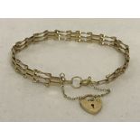 A 9ct gold 3 bar style bracelet with adapted clasp and padlock, complete with safety chain.
