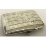 An antique silver cigarette case with engine turned decoration and circular empty cartouche.
