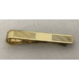 A silver gilt tie pin with engine turned decoration to front.