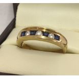 A 9ct gold dress ring with channel set sapphires and clear stones.