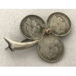 A bespoke brooch in the shape of a clover leaf made from silver 10 cent coins from the Netherlands.