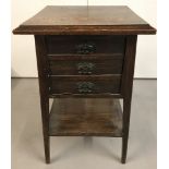 An Arts and Crafts square topped occasional table with spade legs and cupboard.