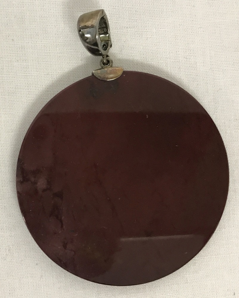 A large circular, modern design, deep burgundy natural stone pendant with push claps fixing bale.