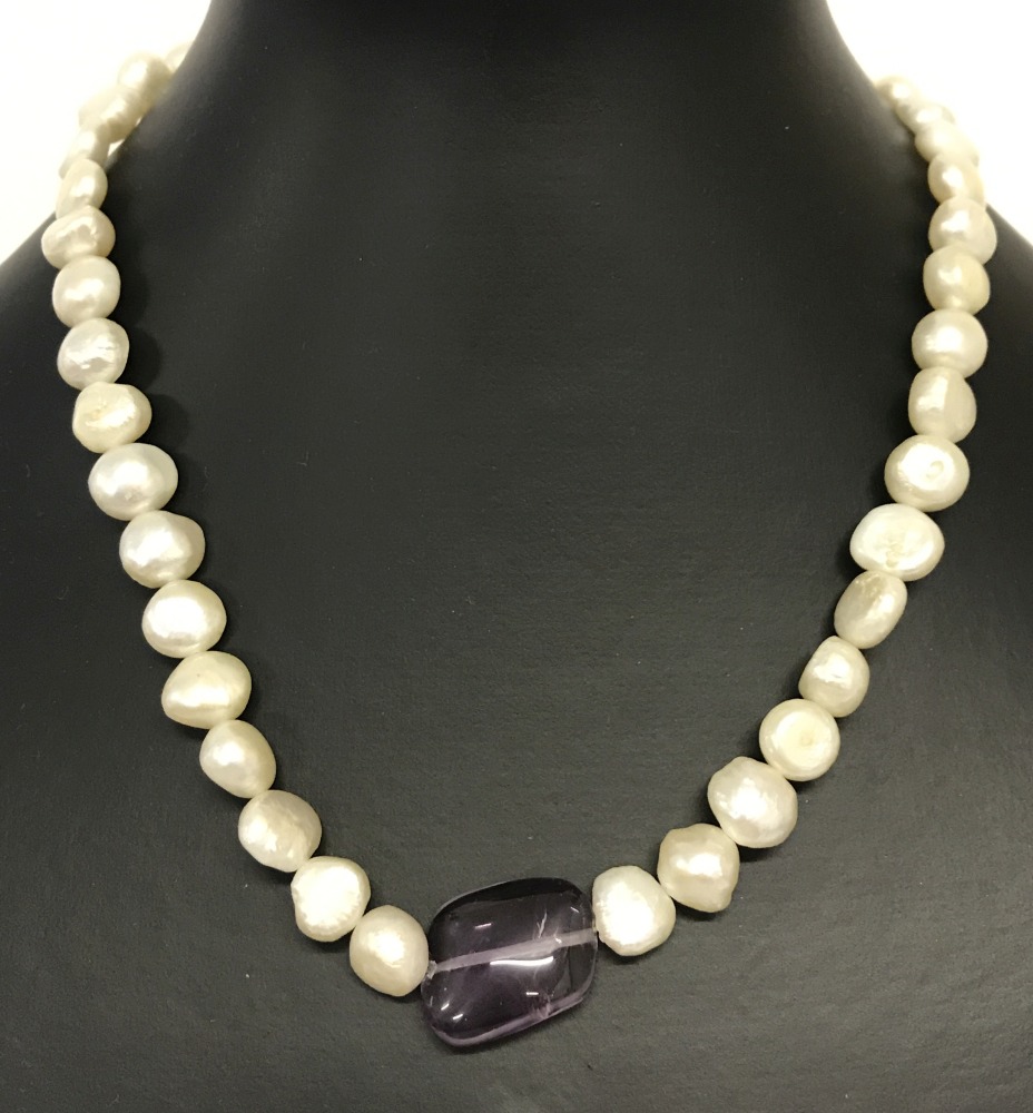 A freshwater pearl and amethyst necklace with large spring clasp fixing.
