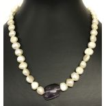 A freshwater pearl and amethyst necklace with large spring clasp fixing.