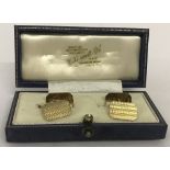 A boxed pair of 9ct gold cufflinks with engine turned decoration.