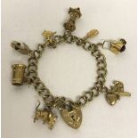A 9ct gold charm bracelet with decorative padlock, safety chain and 8 charms.