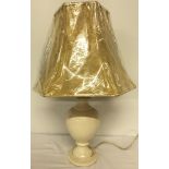A cream crackle glaze table lamp with gold bell shape shade.