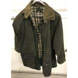 A vintage "Bisley Country Products" wax jacket with chequered lining and pockets to front.