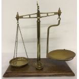 A set of antique brass weighing scales complete with weights.