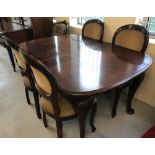 A mahogany wind out extending dining table with 4 matching balloon back dining chairs.