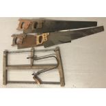 A quantity of vintage wooden handled saws to include 4 hand saws and a bow saw.