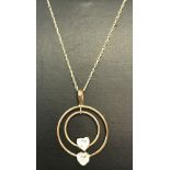 A 9ct gold double circle pendant set with 2 heart shaped clear stones on a fine belcher style chain.