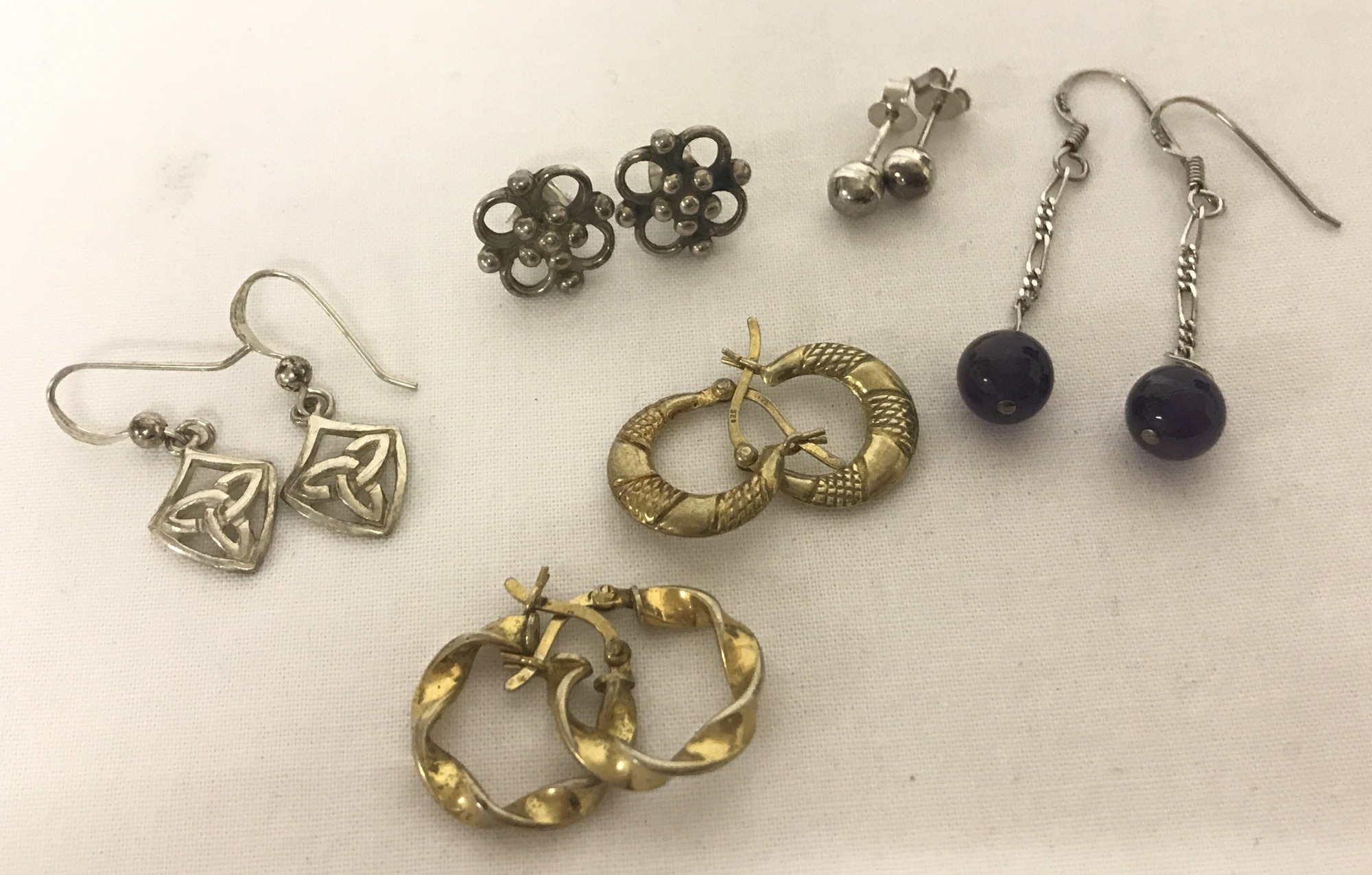 6 pairs of silver and white metal earrings; studs, hoops and drops.