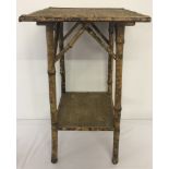 A small vintage bamboo side table with shelf.