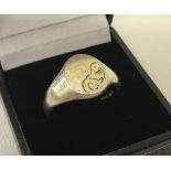 A men's silver signet ring with half engraved detail to empty cartouche.