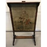 An antique mahogany framed fire screen with tapestry panel of a young girl and lamb.