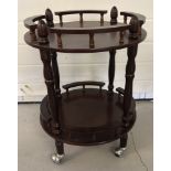 A modern mahogany effect 2 tier circular drinks trolley.