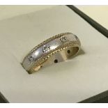 A 9ct yellow and white gold wedding band set with small diamonds.