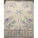 A large cream rug with floral decoration.