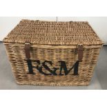 A Fortnum & Mason extra large luxury wicker hamper with fastening straps, carrying handles.