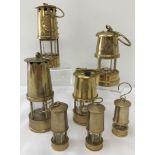 A collection of 7 miniature collectable brass miners lamps.