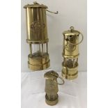 3 vintage brass Welsh miners lamps of differing sizes, each with "Cymru" and Welsh Dragon plate.
