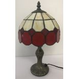 A small Tiffany style table lamp with Art Nouveau style base and cream and red glass shade.