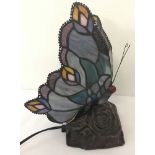 A small Tiffany style table lamp in the shape of a butterfly with leaded glass wing shades.