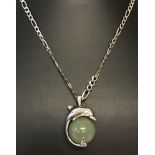 A silver dolphin and green adventurine ball pendant on an 18" silver figaro chain.