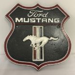 A painted cast iron Ford Mustang wall hanging plaque.